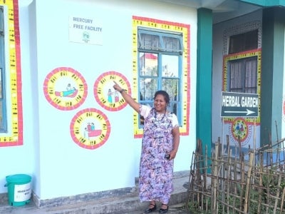 Woman pointing at sign on a building that reads "Mercury free facility"
