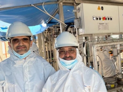 Two men in white protective suits