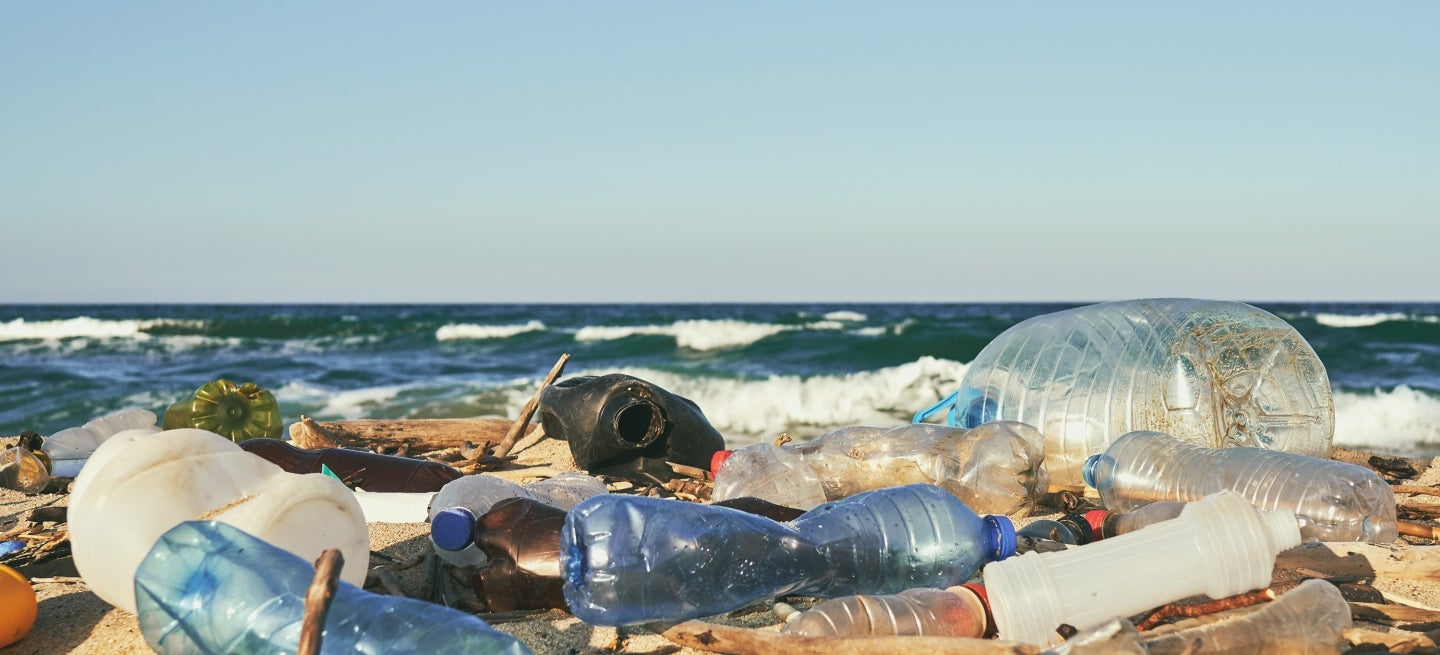 Spilled garbage on the beach of the big city. Empty used dirty plastic bottles. Dirty sea sandy shore the Black Sea. 